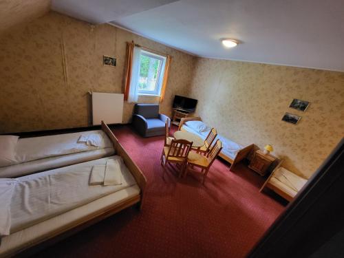 a room with two beds and a table and chairs at Pensjonat Marzenie in Przesieka