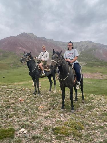 two people riding on horses on a hill at Nice Yurt Camp in Sary-Mogul