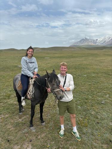 a man and a woman riding a horse in a field at Nice Yurt Camp in Sary-Mogul