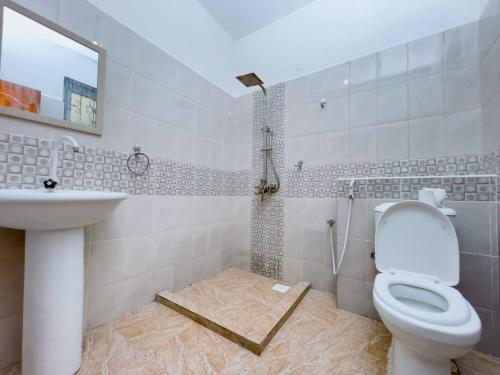 LN NYALI HOMESTAY ENSUITE ROOMs AND APARTMENT WITH SWIMMING POOL في مومباسا: حمام مع مرحاض ومغسلة