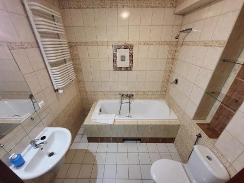 Un baño con bañera, inodoro y lavabo. en Pensjonat Marzenie, en Przesieka