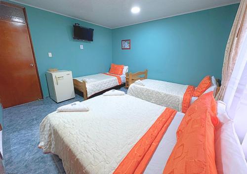 a room with two beds and a tv on the wall at VillaLoren in San Antonio del Tequendama