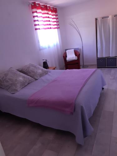 une chambre avec un grand lit avec une couverture violette dans l'établissement Résidence oceane, à Amélie-les-Bains-Palalda