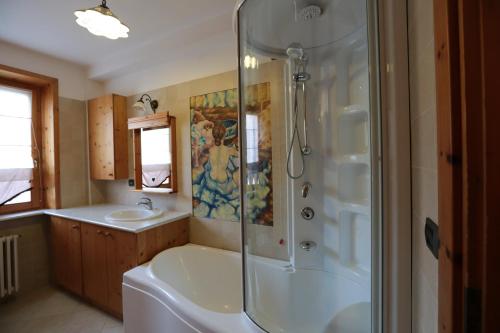 een badkamer met een douche, een bad en een wastafel bij Appartamento Federici in Bormio