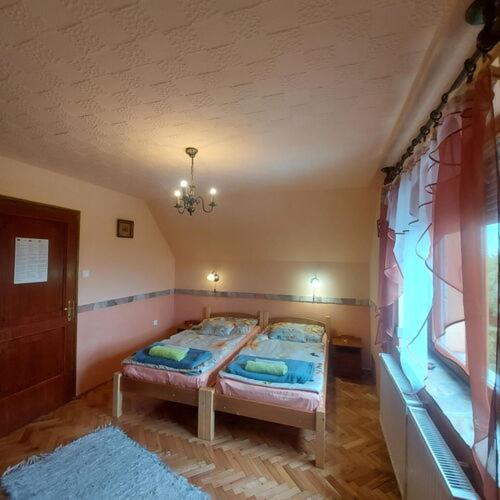 a bedroom with a bed in the corner of a room at Fenyves Vendèghàz in Tapolca