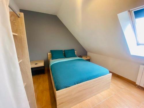 une chambre avec un lit avec des draps bleus et une fenêtre dans l'établissement Maison 1 , possibilité 2 eme maison mitoyenne,Le Crotoy, proche mer - Baie de Somme, au Crotoy