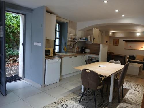 une cuisine et une salle à manger avec une table et des chaises dans l'établissement Maison au pied du château, terrasse, à Grignan