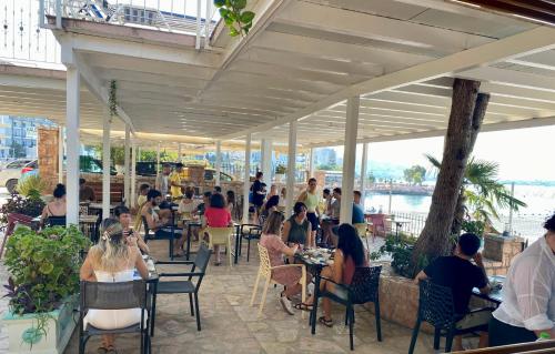 a group of people sitting at tables in a restaurant at Kalemi's Beachside Hotel in Sarandë