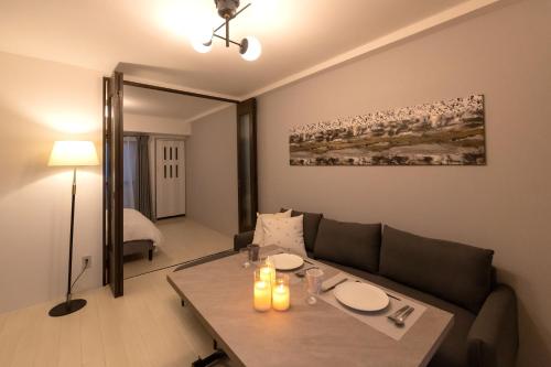 a living room with a couch and a table at Dotonbori East Residence Haru - Self Check-In Only in Osaka