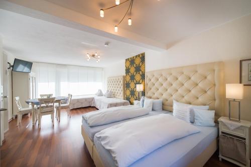 バート・ヘルスフェルトにあるホテルペンション ビタリスのベッドルーム1室(大型ベッド1台付)、ダイニングルームが備わります。