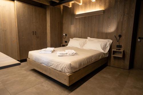 a bedroom with a bed with two towels on it at Le Suites de San Campel RTA in Ponte di Legno