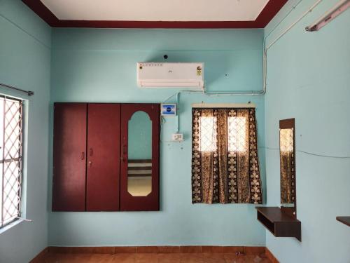 a room with blue walls and a mirror at Holiday Home Madurai CS Nagar - GF in Madurai