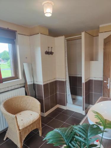 La salle de bains est pourvue d'une douche et d'une chaise. dans l'établissement Gîtes les Deux Vallées, à Le Bois-Hellain
