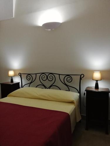 a bedroom with a bed with two night stands and two lamps at CH Guest Rooms in Vernole