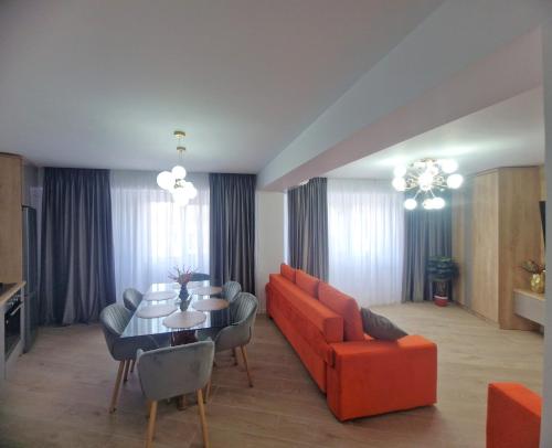 un soggiorno con divano arancione e tavolo di Ultracentral Luxury Apartament a Curtea de Argeş