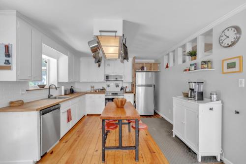 a kitchen with white cabinets and a wooden table at Robin's Rest home in Chapel Hill