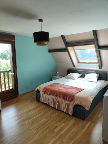 une chambre avec un lit avec un mur bleu dans l'établissement Gîtes les Deux Vallées, à Le Bois-Hellain
