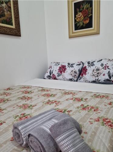 a bed with a comforter and a blanket on it at Quartos na Montanha in Siderópolis
