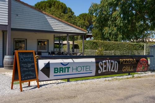 a sign in front of a bar with a sign for a bait house at Brit Hotel Confort Manosque Cadarache in Manosque