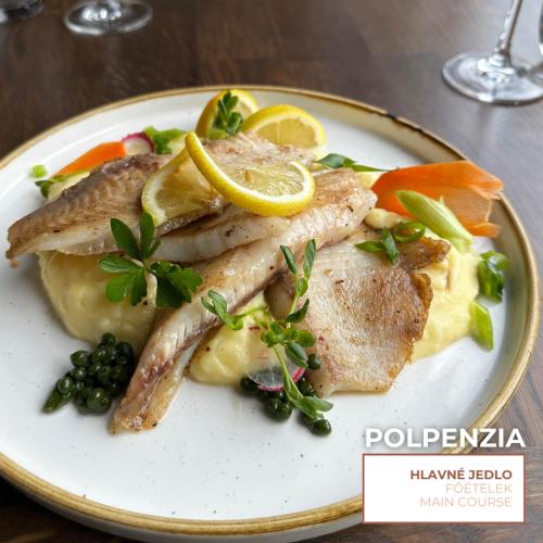 a plate of food with fish and vegetables on a table at HOTEL EUROPA in Komárno