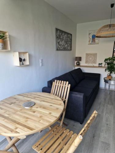 un salon avec une table et un canapé dans l'établissement valras plage à 5 minutes de la mer, à Valras-Plage