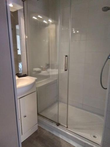 une salle de bain blanche avec une douche et un lavabo dans l'établissement valras plage à 5 minutes de la mer, à Valras-Plage