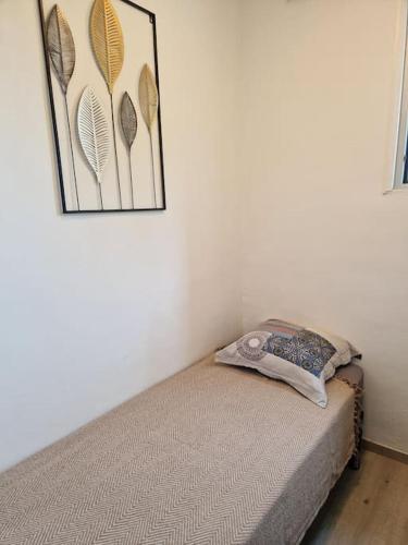 - un lit dans une chambre avec une photo sur le mur dans l'établissement valras plage à 5 minutes de la mer, à Valras-Plage