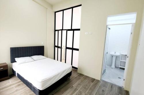 ein Schlafzimmer mit einem Bett und ein Badezimmer mit einem Waschbecken in der Unterkunft Residencia en Tarapoto Casa San Pedro in Tarapoto