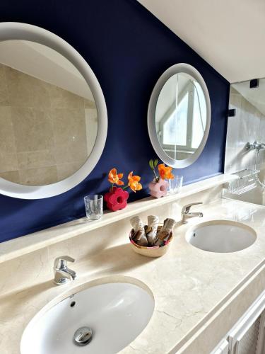 two sinks in a bathroom with two mirrors at Soto Blues Sotogrande - Puerto Deportivo in Sotogrande
