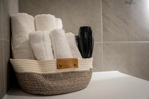 a basket filled with towels on a toilet in a bathroom at Grey Comfort in Glinado Naxos