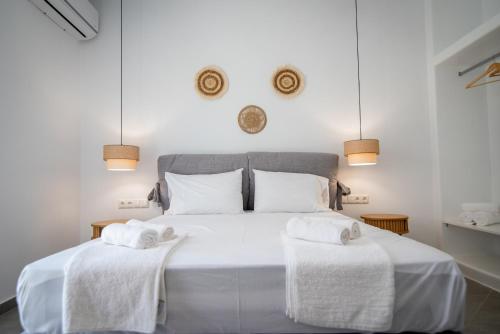 a bedroom with a white bed with two towels at Grey Comfort in Glinado Naxos