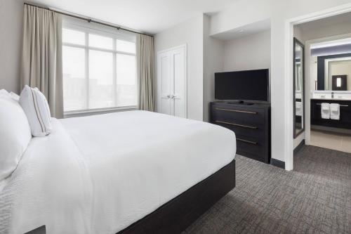a bedroom with a large bed and a flat screen tv at Residence Inn Long Island Garden City in Garden City