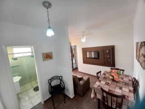 a living room with a table and a television at Apartamento do Simão in Praia Grande