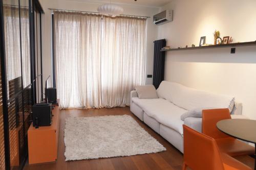 a living room with a white couch and a television at Krtsanisi Grande apartment in Tbilisi City