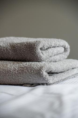 a pile of towels sitting on top of a bed at Pokoje nad Kłodnicą in Gliwice