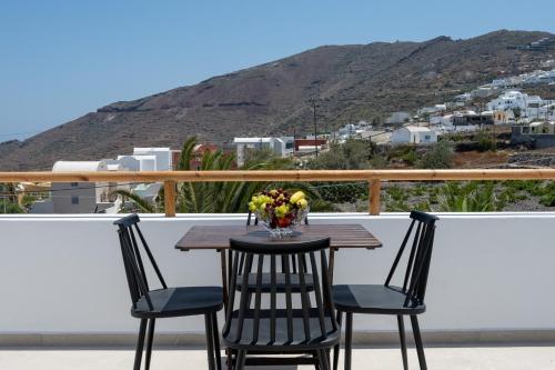 a table with a vase of flowers on a balcony at Theophrasti Suites in Foinikiá