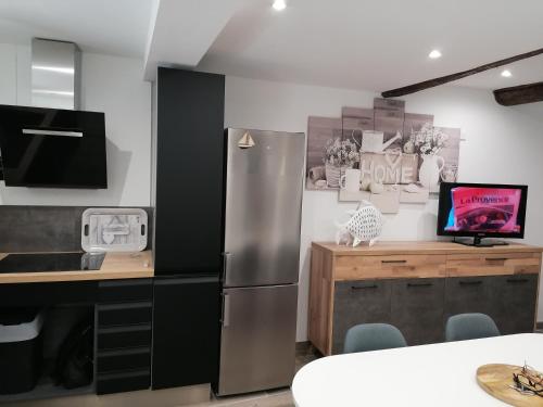 Il comprend une cuisine équipée d'un réfrigérateur en acier inoxydable et d'un bureau. dans l'établissement La Cigale, à La Ciotat