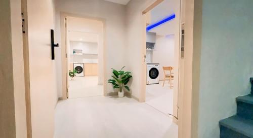 a hallway with a door open to a room with a plant at New Ekamai Thonglor Luxury Home near 711, BTS, Mall in Klong Toi