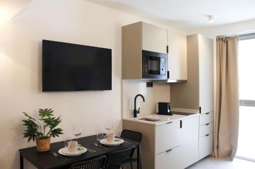 una cucina con tavolo da pranzo e una cucina con armadietti bianchi di Style Madrid Center Santiago Bernabeu a Madrid