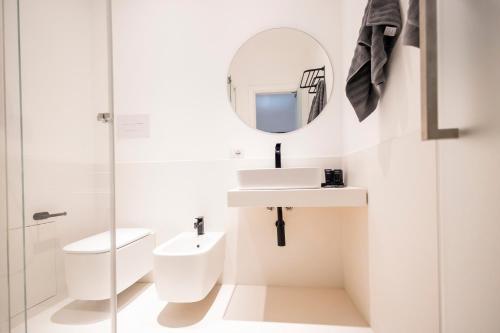 a bathroom with a toilet and a sink and a mirror at Caveau in Palermo