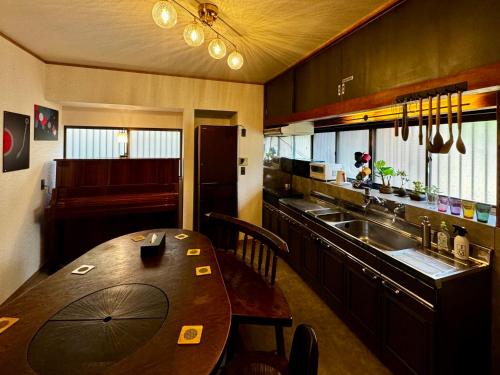 Yawata加美屋リゾート房総 浪漫ラウンジ 夕日と露天風呂-Kamiya Resort Boso的带木桌的厨房和餐厅