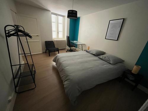 - une chambre avec un lit, un bureau et une chaise dans l'établissement Appartement centre ville Charolles, à Charolles