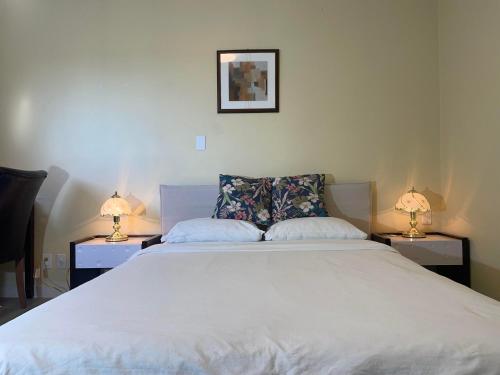 a bedroom with a large white bed with two lamps at New Master room & private washroom 203 in Richmond