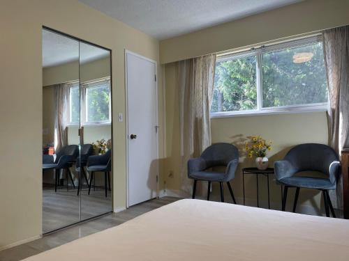 a bedroom with a mirror and chairs and a table at New Master room & private washroom 203 in Richmond