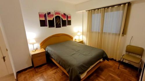 - une chambre avec un lit, deux lampes et une chaise dans l'établissement EfDepartamentos Plaza Colon con balcón a la calle, à Mar del Plata