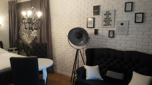 a bedroom with a bed and a table and a couch at Piękna Apartments White in Łomża