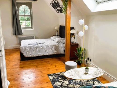 a bedroom with a bed and a table in it at La Villa Bligny in Étretat