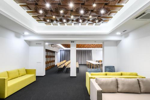 an office lobby with yellow couches and chairs at Hotel Etar in Gabrovo