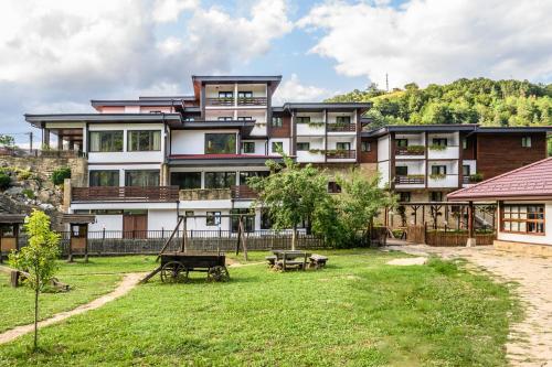 an apartment building with a park in front of it at Hotel Etar in Gabrovo