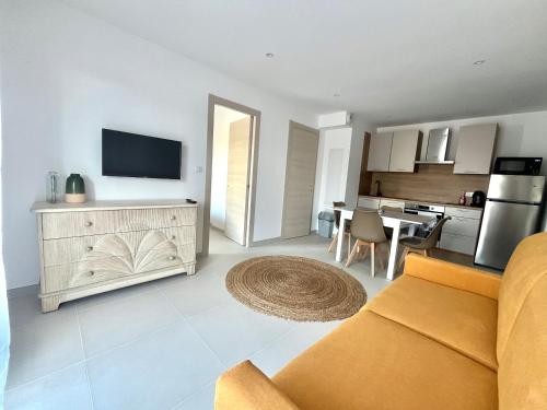 un salon avec un canapé et une cuisine dans l'établissement Agosta Porticcio - Plage à 200m - T2 SUN entre mer & maquis - Barbecue- rés Fiore di maghja - PARKING - Wifi - 4 Pers, à Les Hameaux de Porticcio